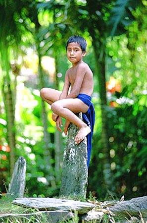 A boy sitting on the stone money, Yap Island, Micronesia.