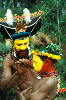 Before a Sing-sing dance, the chief of Huli applies make-up to a boy.